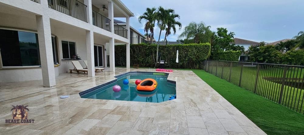 Luxury backyard with pool, sun loungers, and vibrant floaties in a tropical setting.