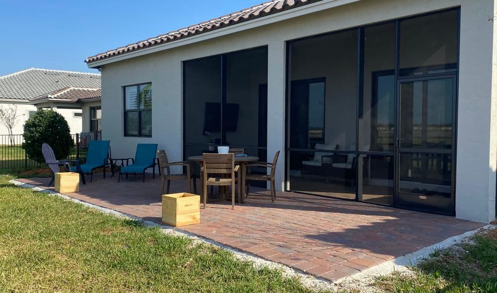 Relaxing patio with seating, dining table, and screens; perfect for outdoor enjoyment.